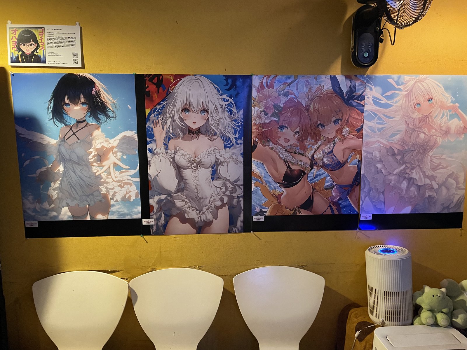 壁に張り出された AI 生成のアニメ風女性キャラクターのポスター 4 枚、衣装は天使羽根や夏服など多様、画面下に白い椅子と空気清浄機