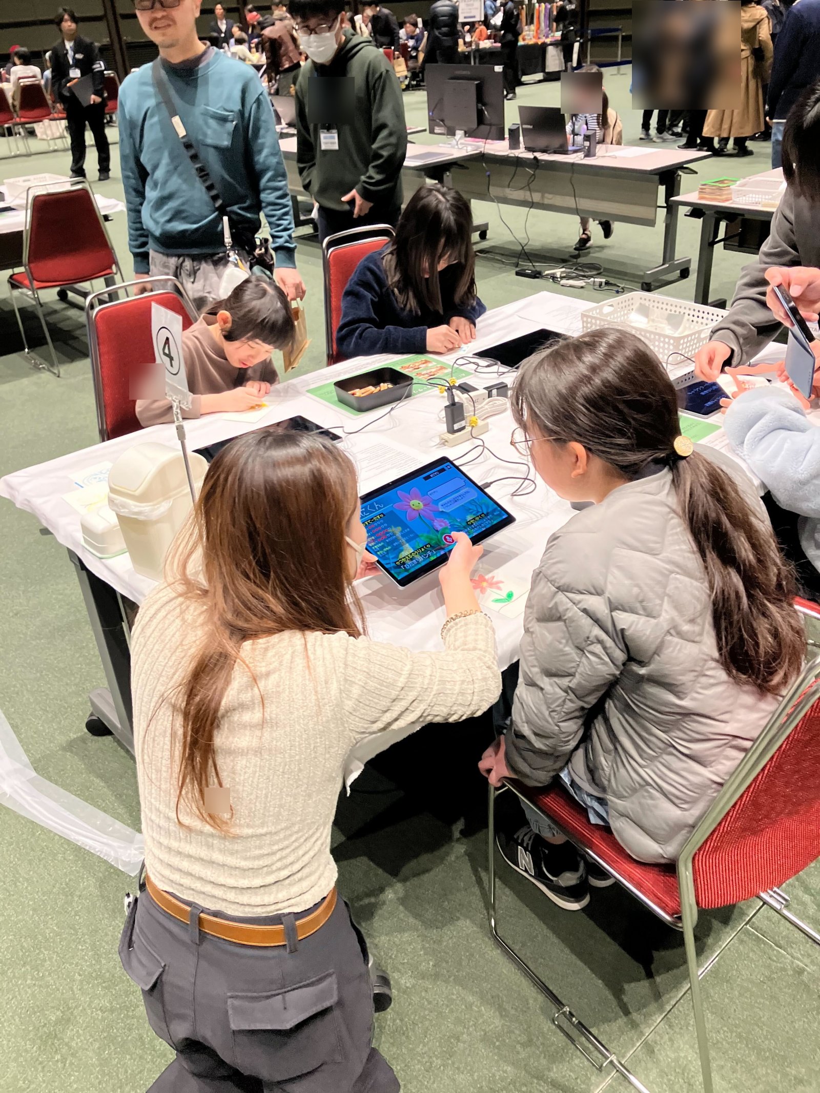 子どもたちが紙に絵を描きながら iPad で AI-KATA S2P キッズを操作する様子