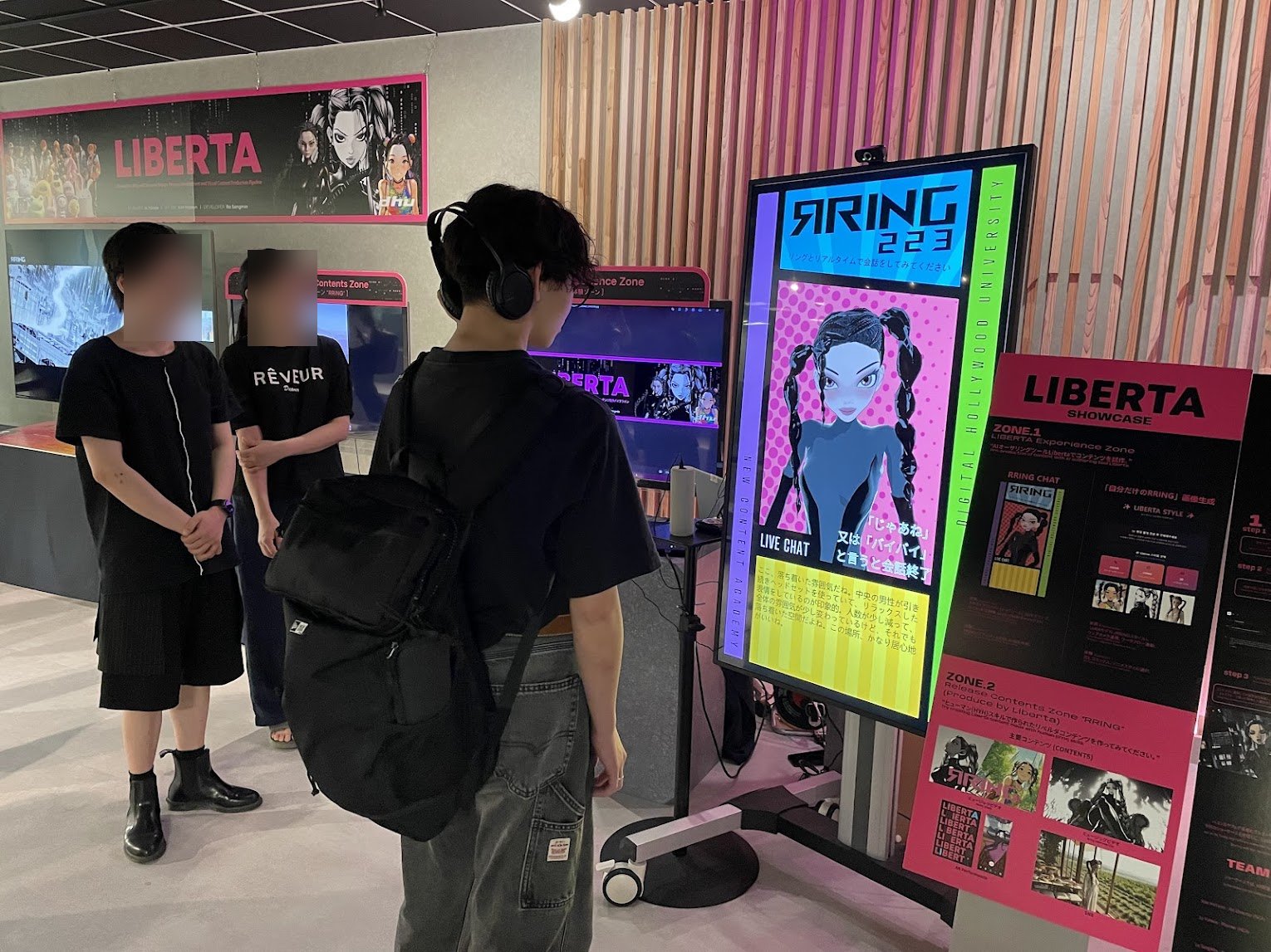 デジタルハリウッド大学 LIBERTA SHOWCASE での AI VTuber「RING 223」展示。LIVE CHAT を体験する来場者